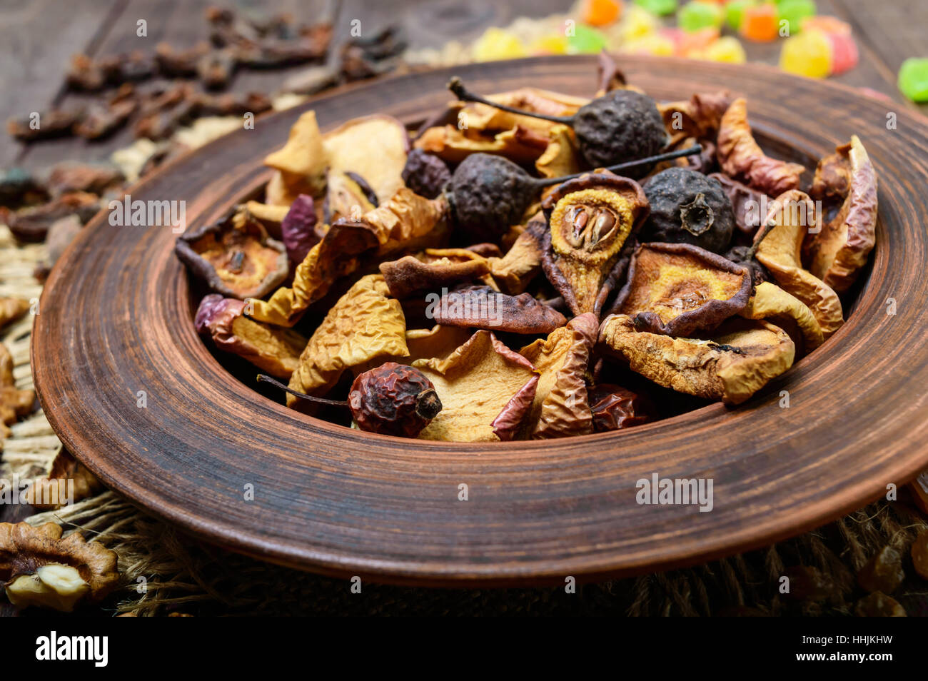 Dried fruit (apples, pears, apricots), berries, raisins and nuts in a bowl on dark wooden background. Close up. Stock Photo