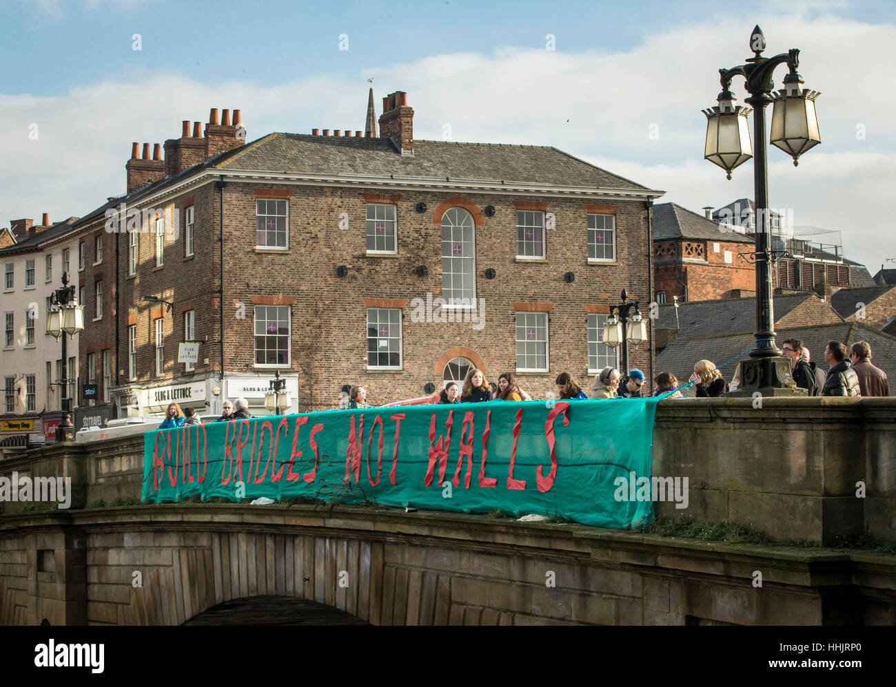A banner is unfurled on the Ouse bridge in York as part of the Bridges Not Walls protest against US President Donald Trump on the day of his inauguration. Stock Photo