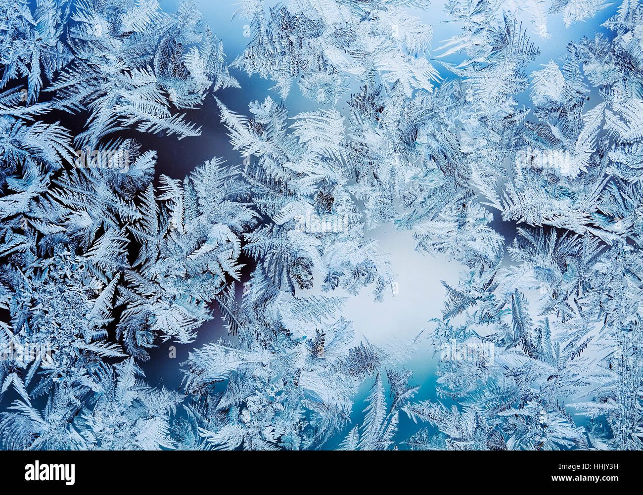 Intricate, delicate patterns of frost crystals on a sparkling glass ...
