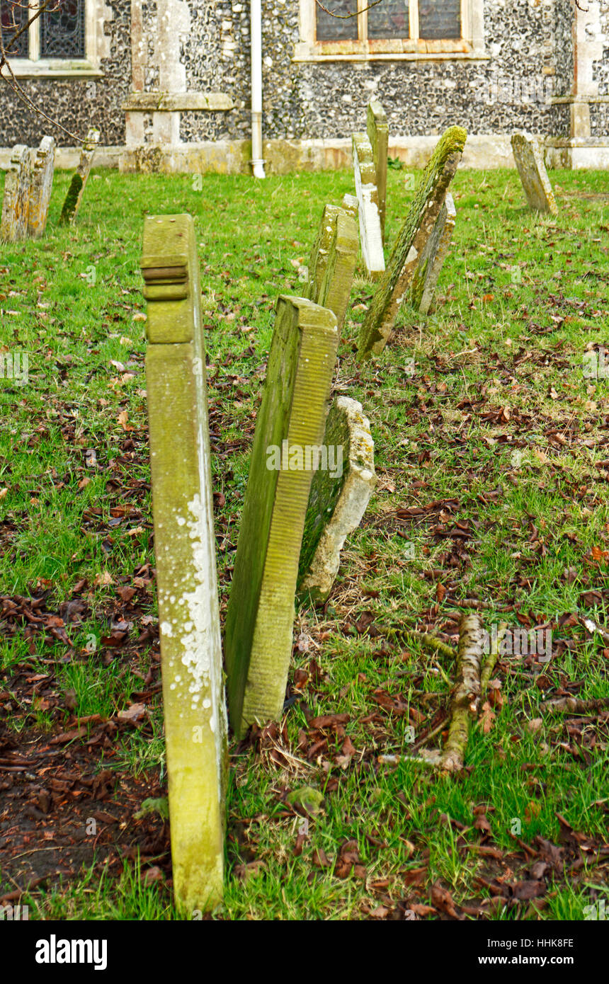 A row of leaning headstones in the churchyard of the parish church at North Elmham, Norfolk, England, United Kingdom. Stock Photo