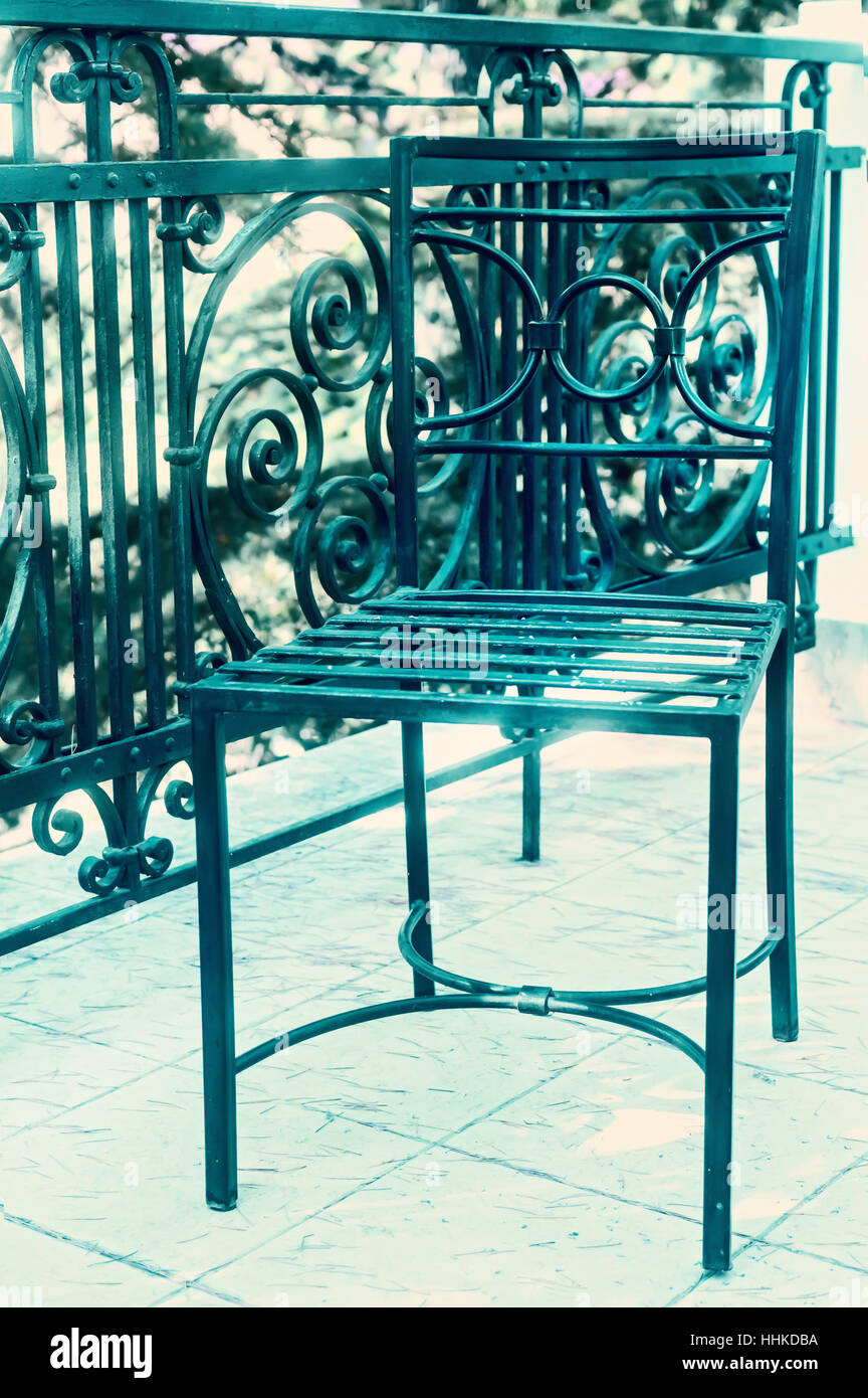 Cast-iron chair on balcony in sepia light Stock Photo