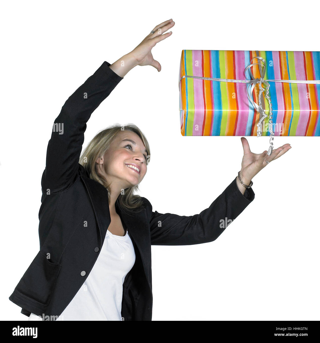 Studio photography of a cute girl while catching a gift box, isolated on white Stock Photo