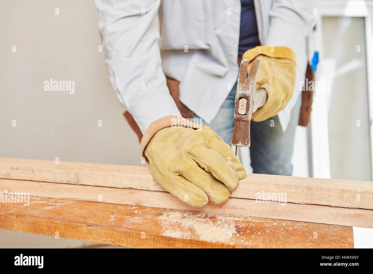 Carpenter hammering on wood during construction Stock Photo