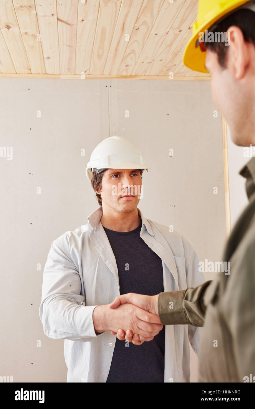 Construction workers sharing handshake as agreement Stock Photo