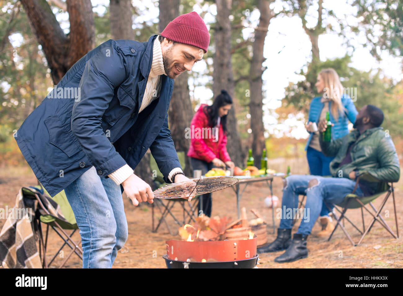 Man kindling fire on grill Stock Photo