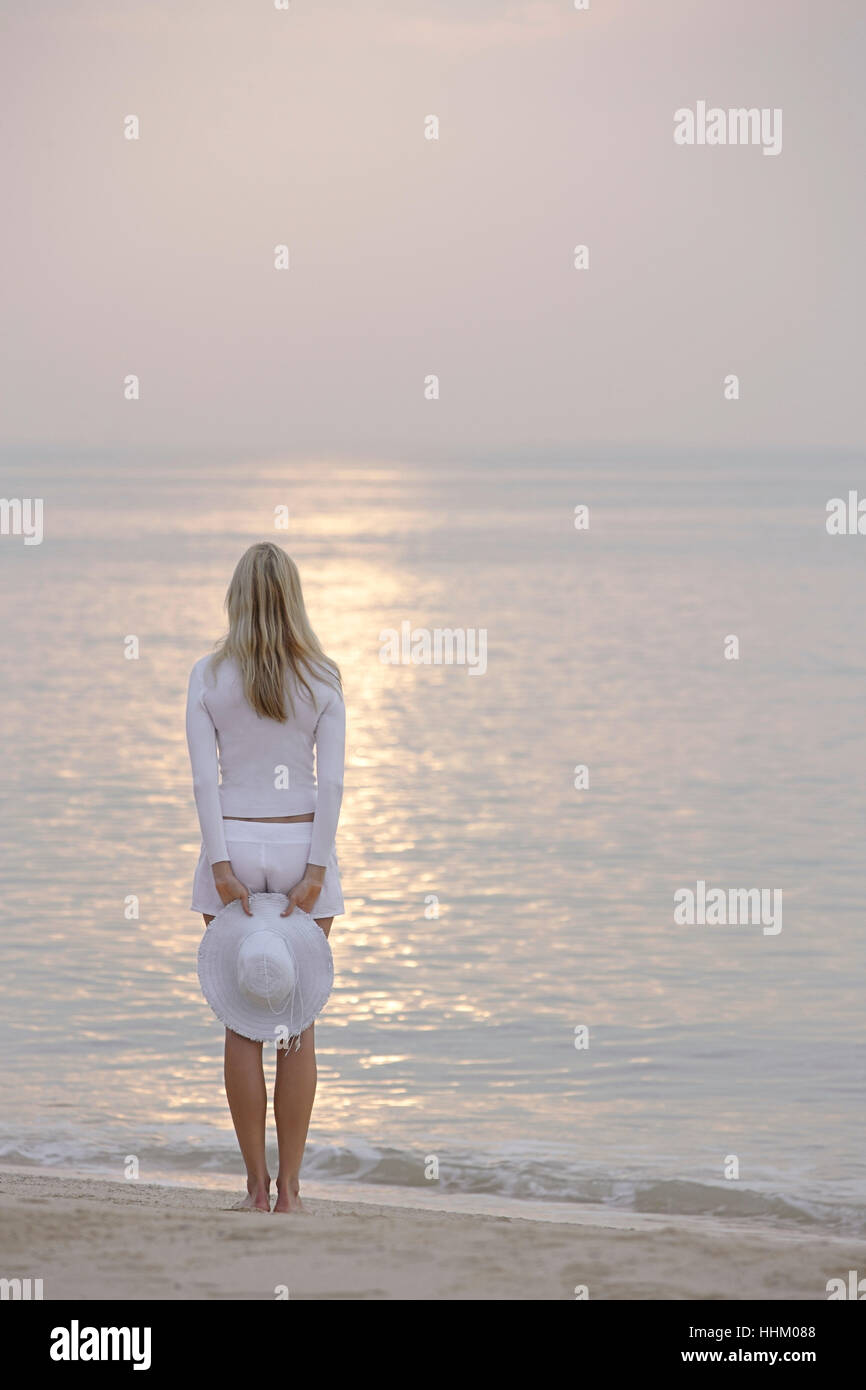 woman standing on beach, looking at ocean Stock Photo - Alamy