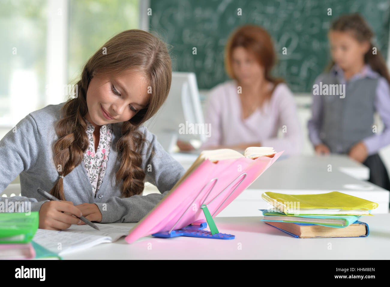 teacher with two girls at lesson Stock Photo - Alamy