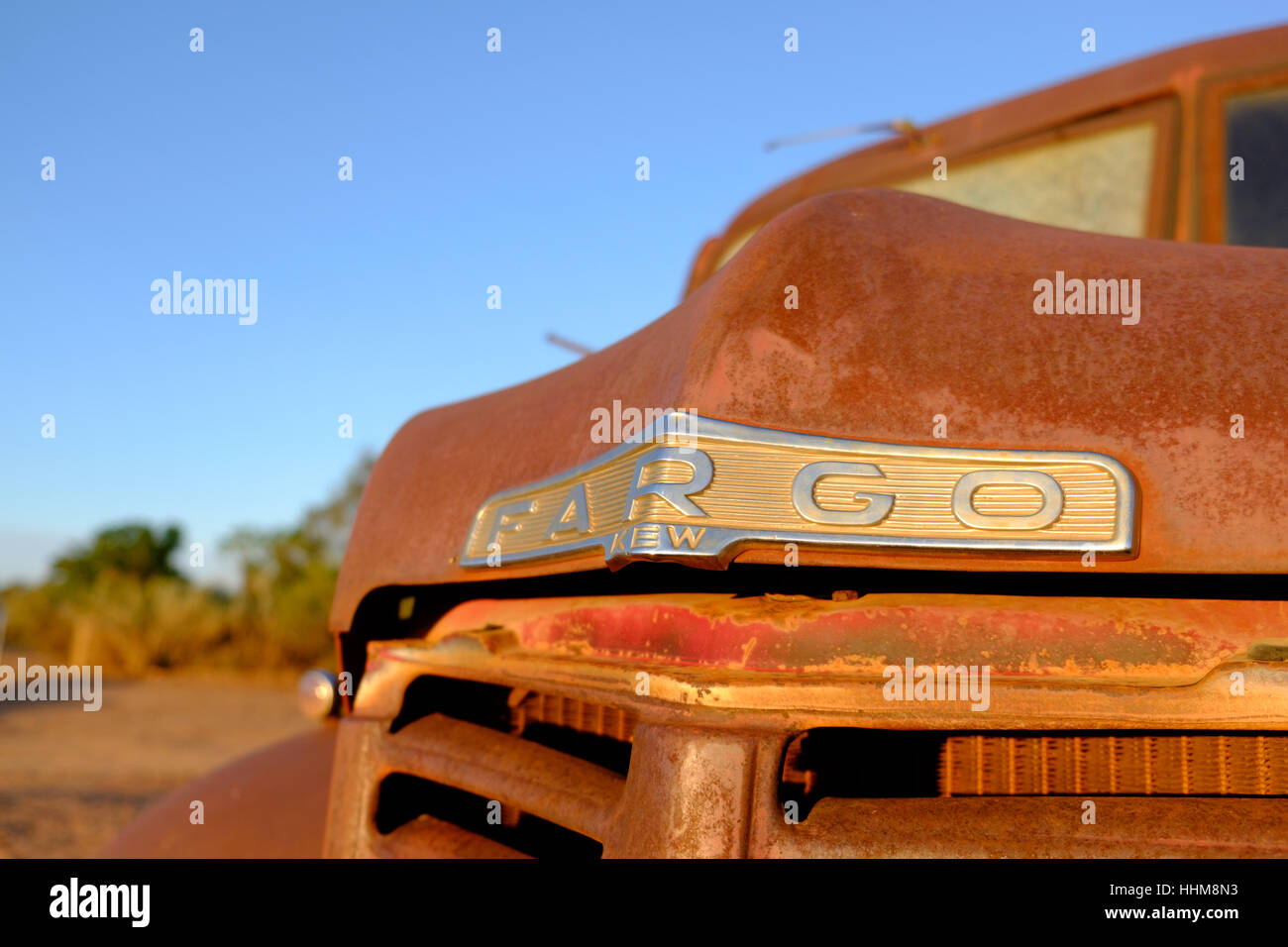 Rusty old wreck of a Fargo truck in early morning light, in a desert setting in the Australian outback Stock Photo