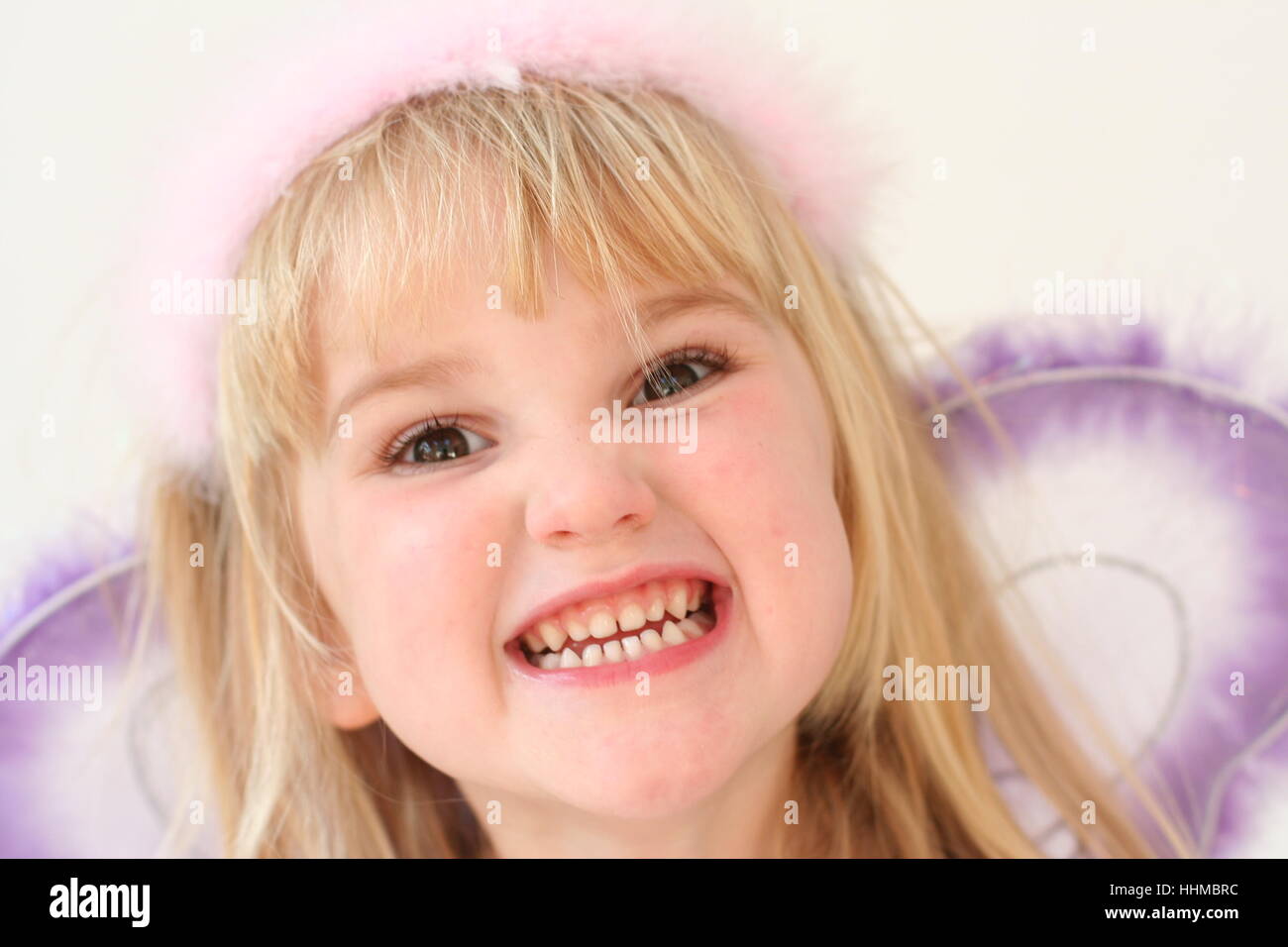 Child dressed as a fairy making a funny face with clenched teeth Stock Photo