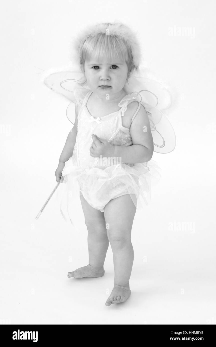 little baby girl wearing a tutu and fairy wings and wand, dressup up as a baby fairy fairies, child fairy dress, magic concept, make believe, joy Stock Photo