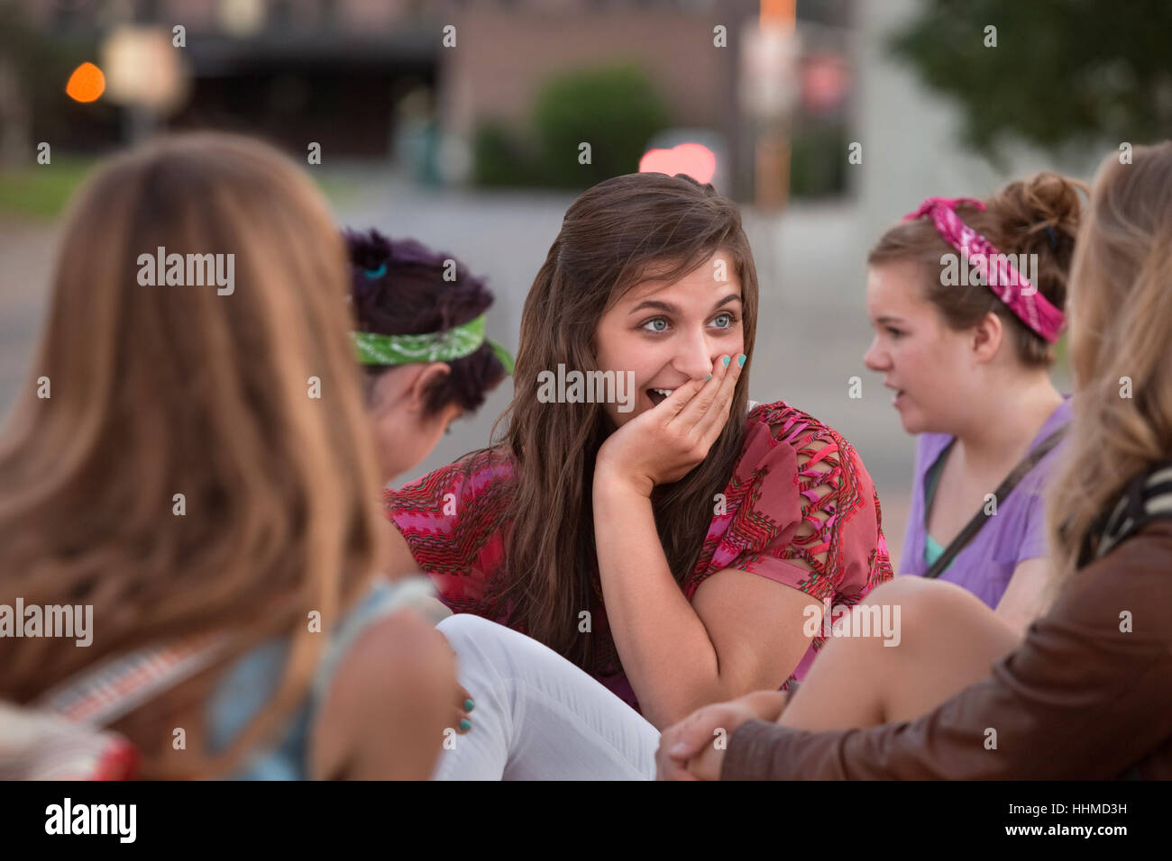 Embarrassed teenage girl with hand on mouth among friends Stock Photo ...
