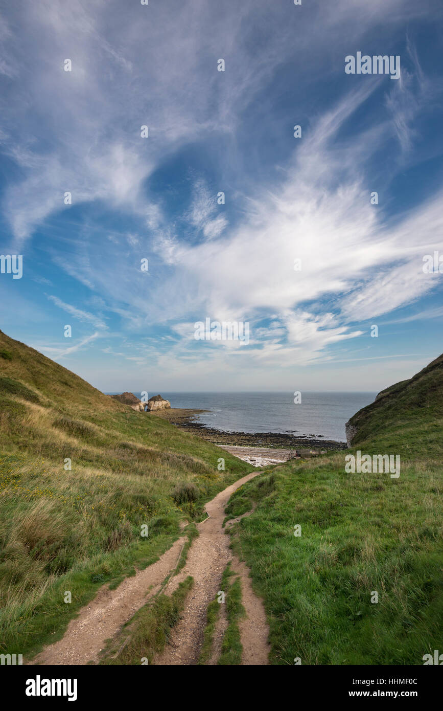 Wispy clouds above Thornwick bay on the coast of North Yorkshire, England. Stock Photo