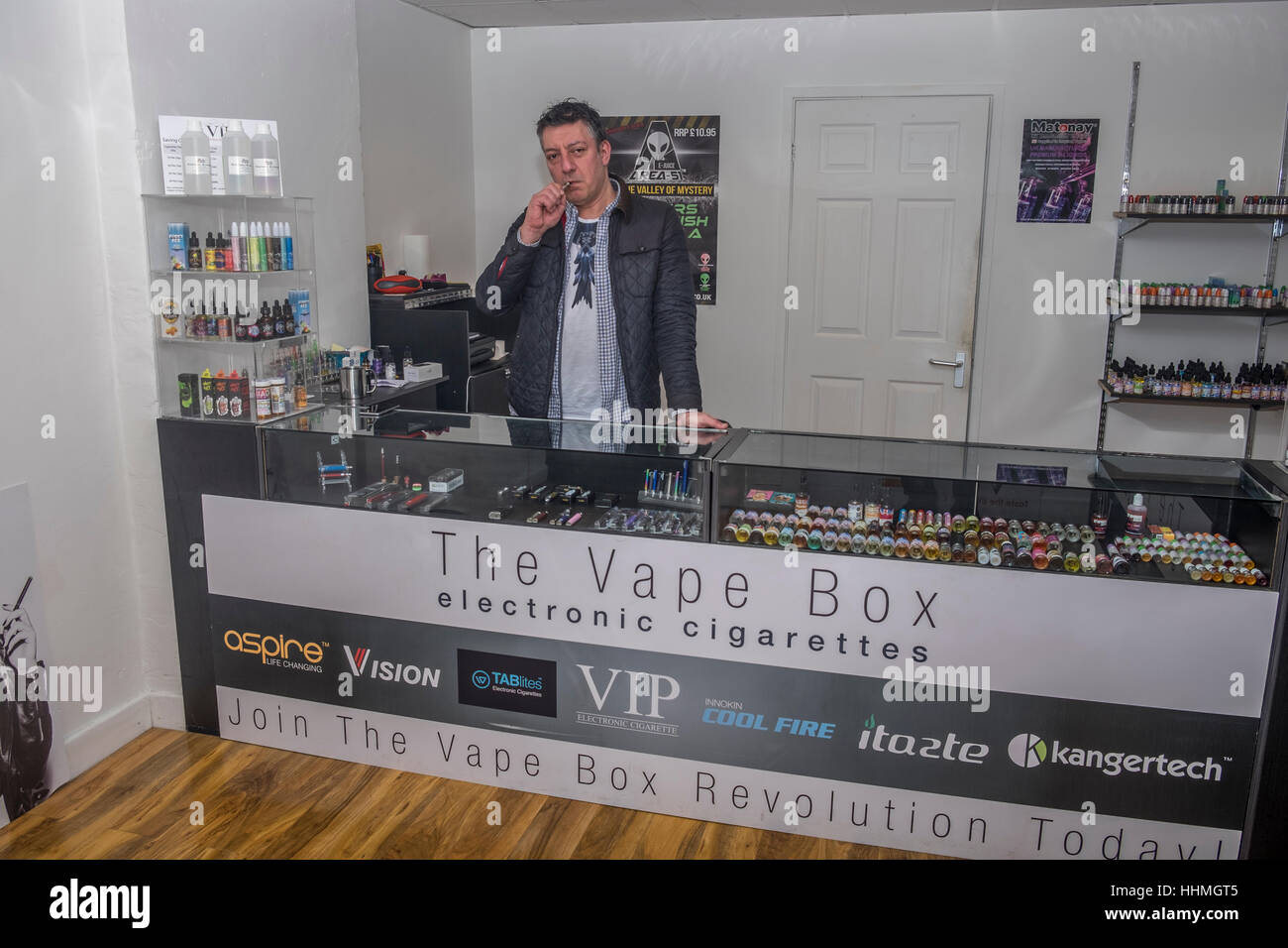 A Vape shop owner showing how to vape a e-cigarette. Stock Photo