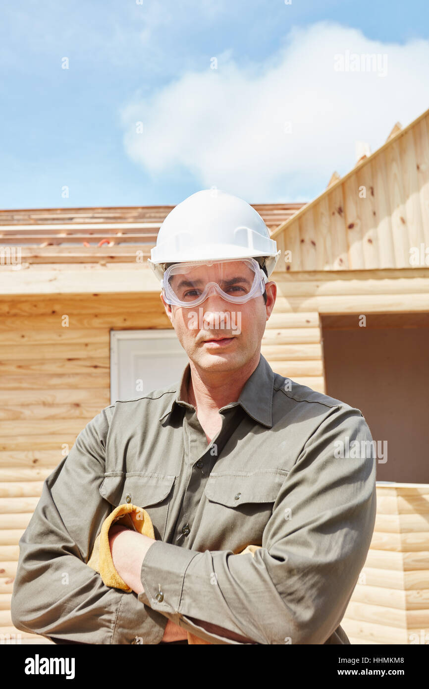 Skilled blue collar worker at construction site building new woodhouse Stock Photo