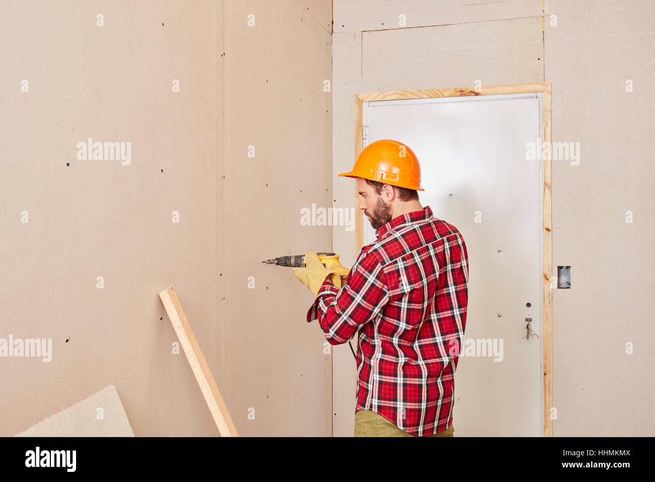 Carpenter working with drilling machine and cladding wall Stock Photo