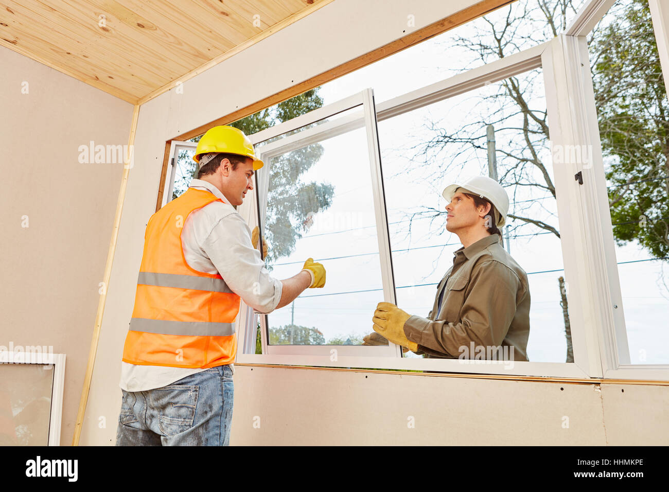Mechanichs assembling window mount at woodhouse in construction Stock Photo