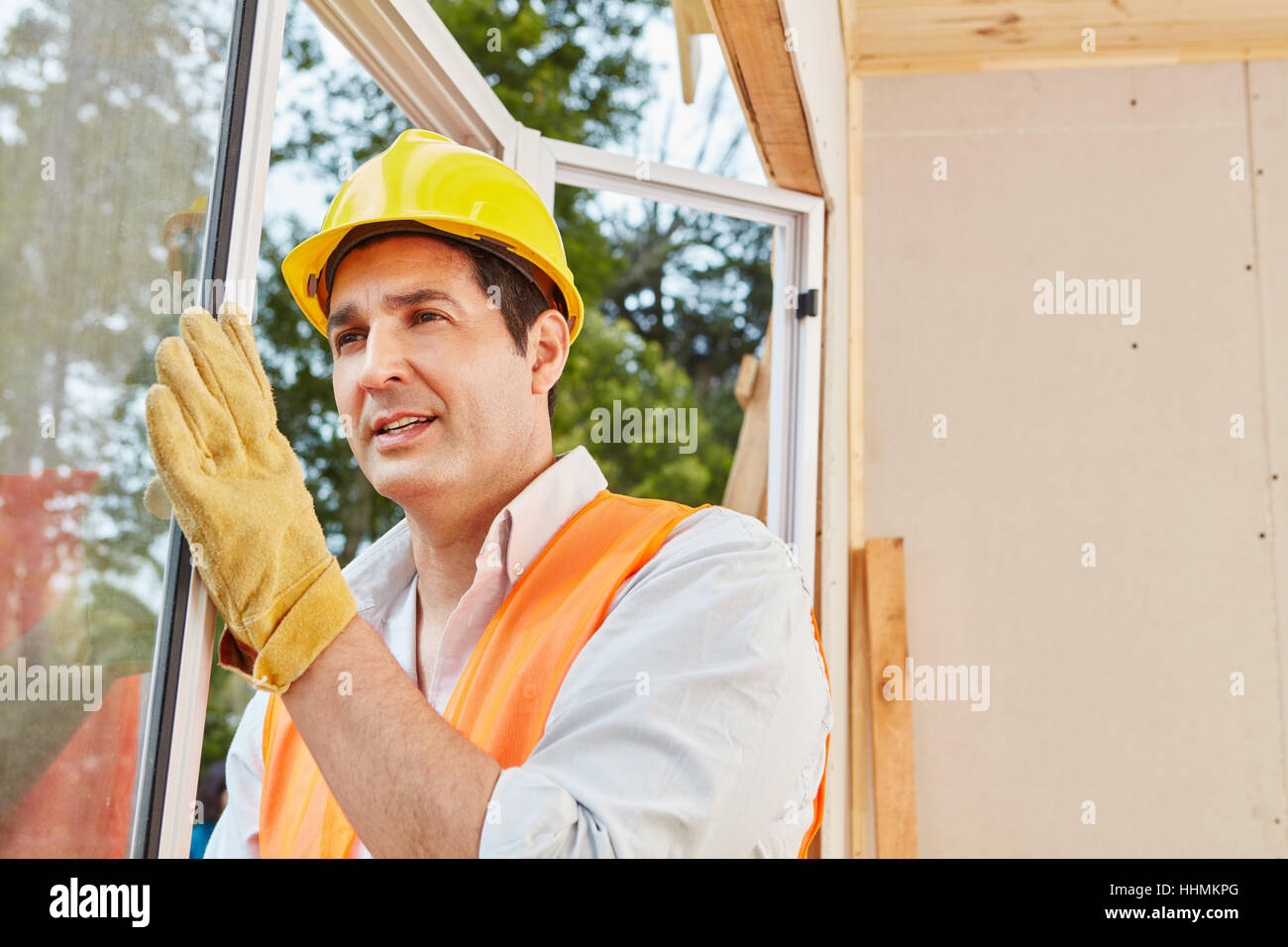 Skilled window fitter mounting window installation at woodhouse Stock Photo