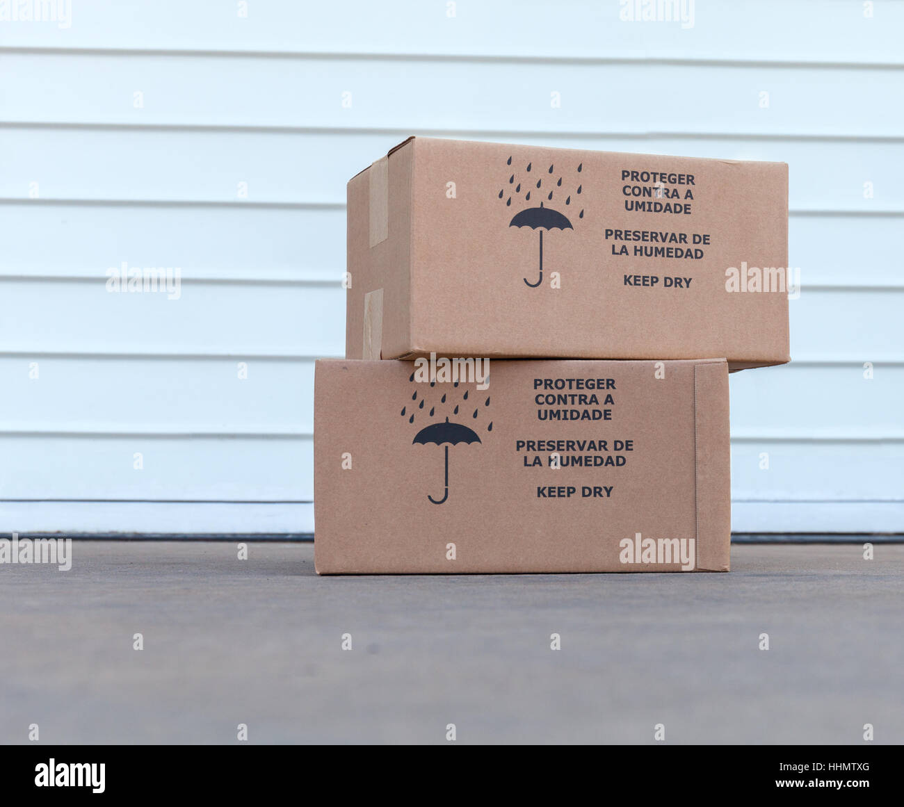 Pile of cardboard boxes over white warehouse door background Stock