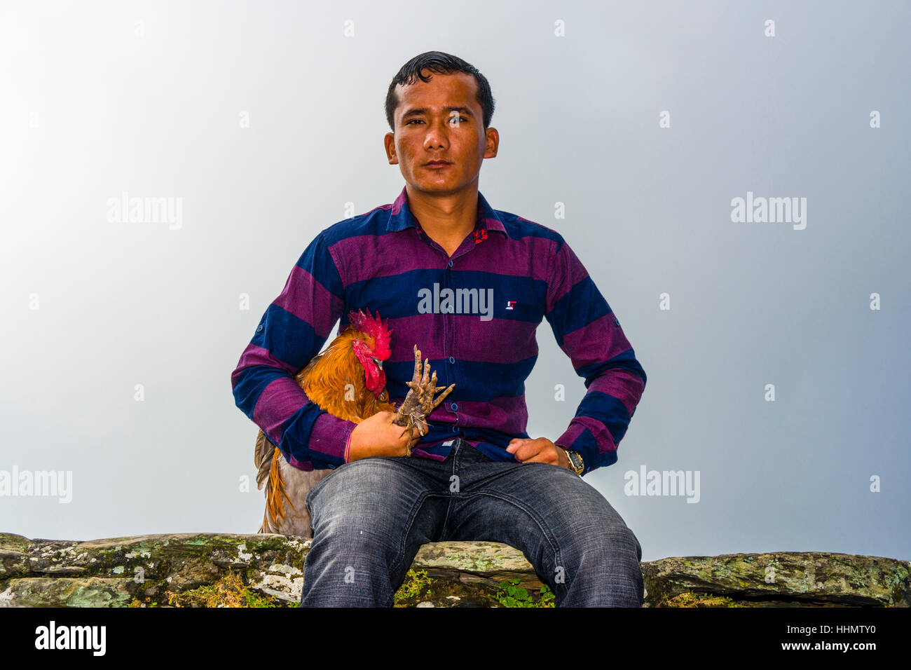 Local man sitting with a rooster, soon to be sacrificed at the Khadga Devi Mandir Temple, Darsain Hindu Festival, Bandipur Stock Photo
