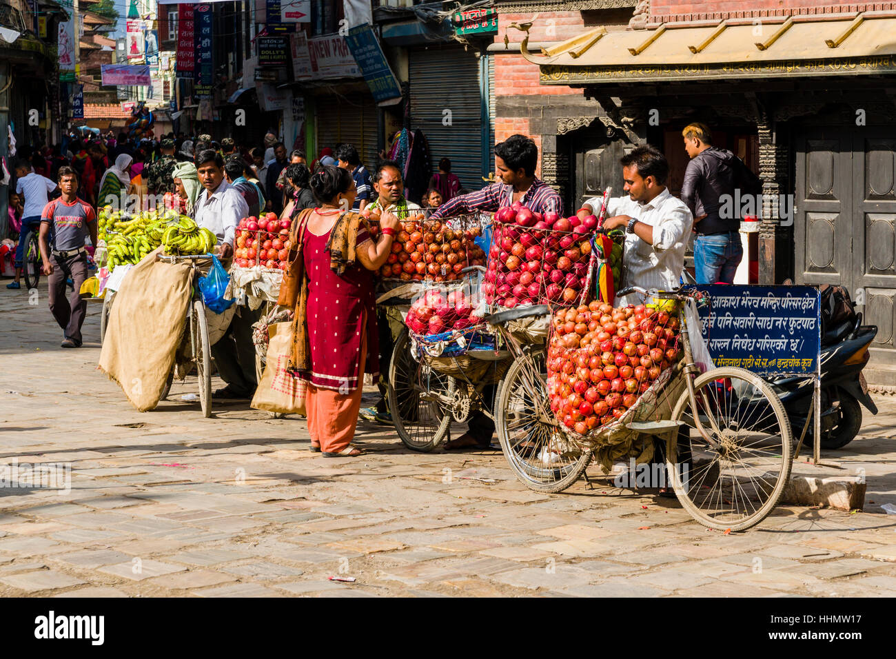 Fruit sellers, using bicycles, are offering apples and oranges on Indra Chowk market square, Kathmandu, Kathmandu District Stock Photo