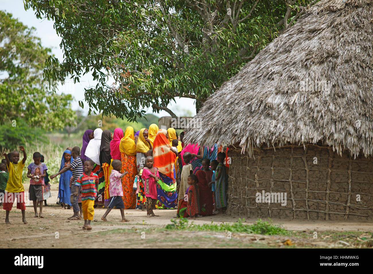 Women and children in colourful clothing next to mud hut, Orma ethnic community, Marafa, Tana River Delta, Kenya Stock Photo