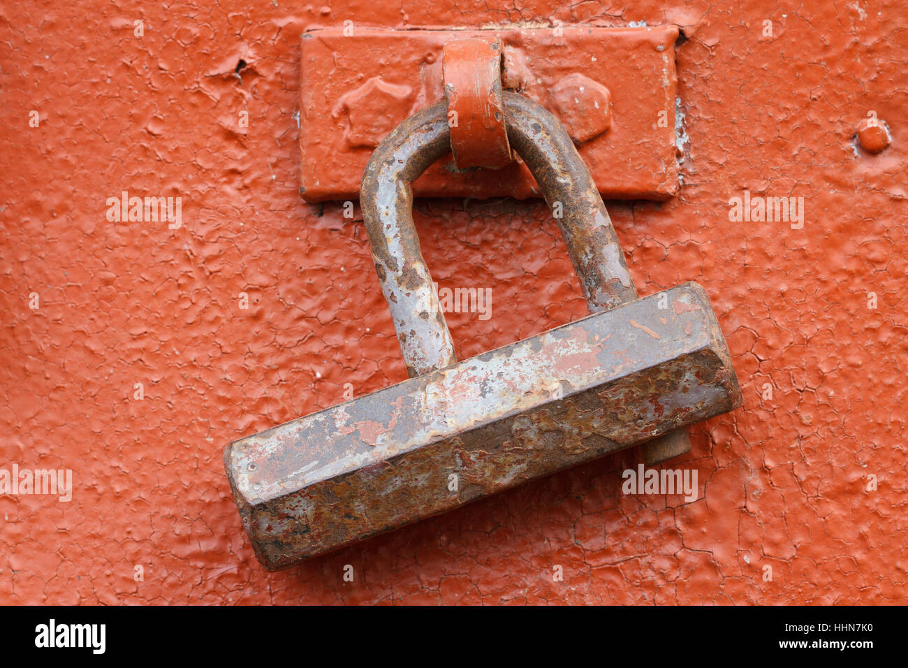 old rusty padlock on a red iron door closeup Stock Photo