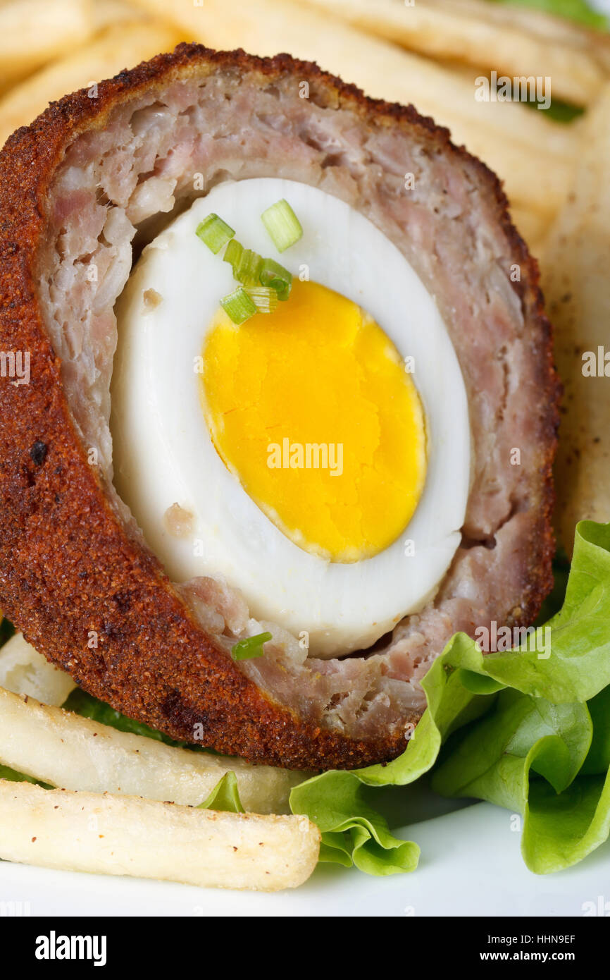 Meat stuffed eggs with french fries and lettuce on a plate macro. vertical Stock Photo