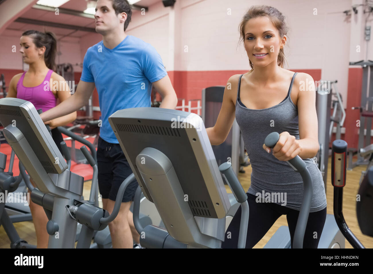 Three people stepping on step machine in gym Stock Photo Alamy