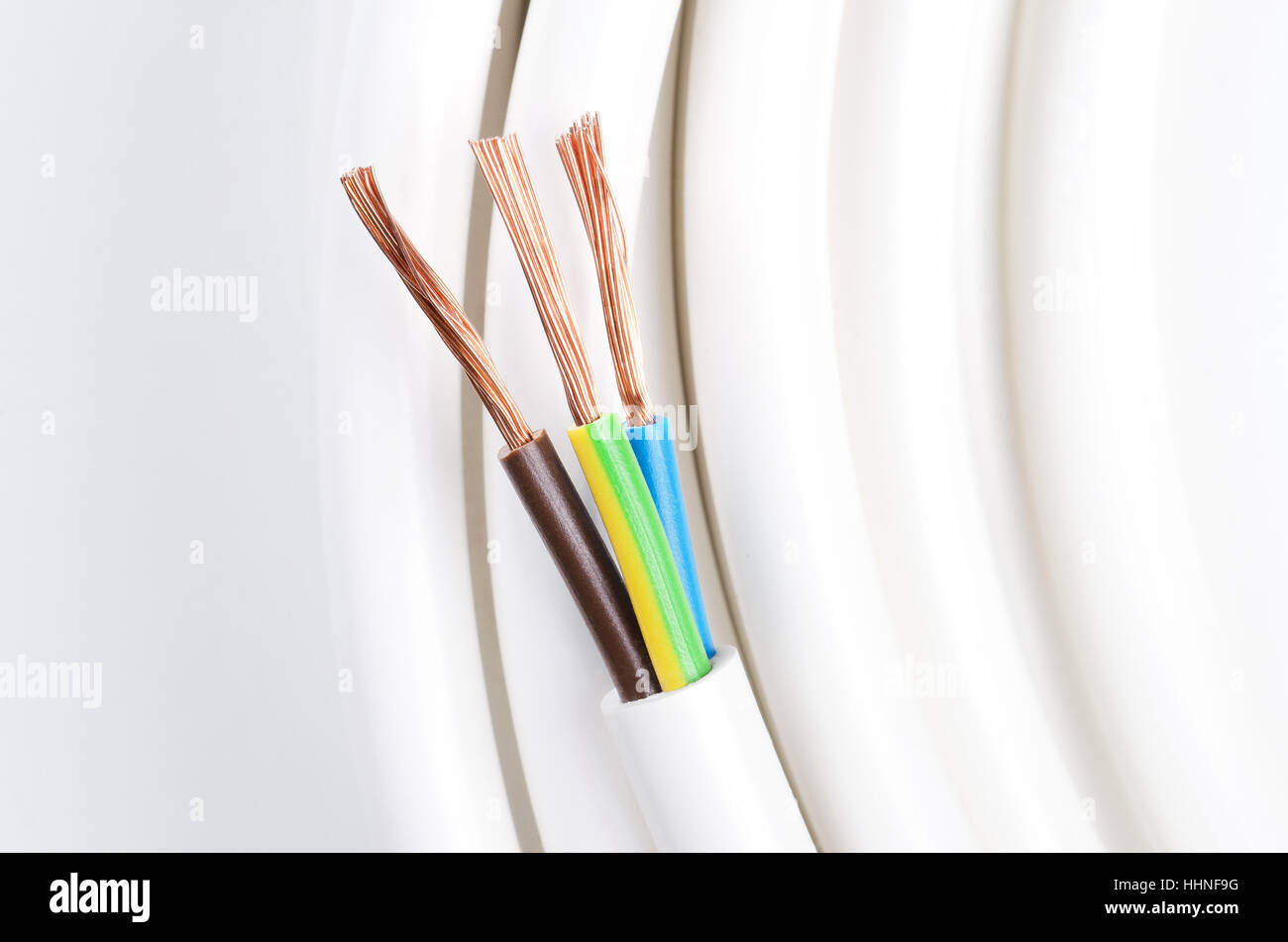 Electrical cable with three insulated conductors. Power cable cross-section. Cable jacket with wire insulation and copper wires. Stock Photo