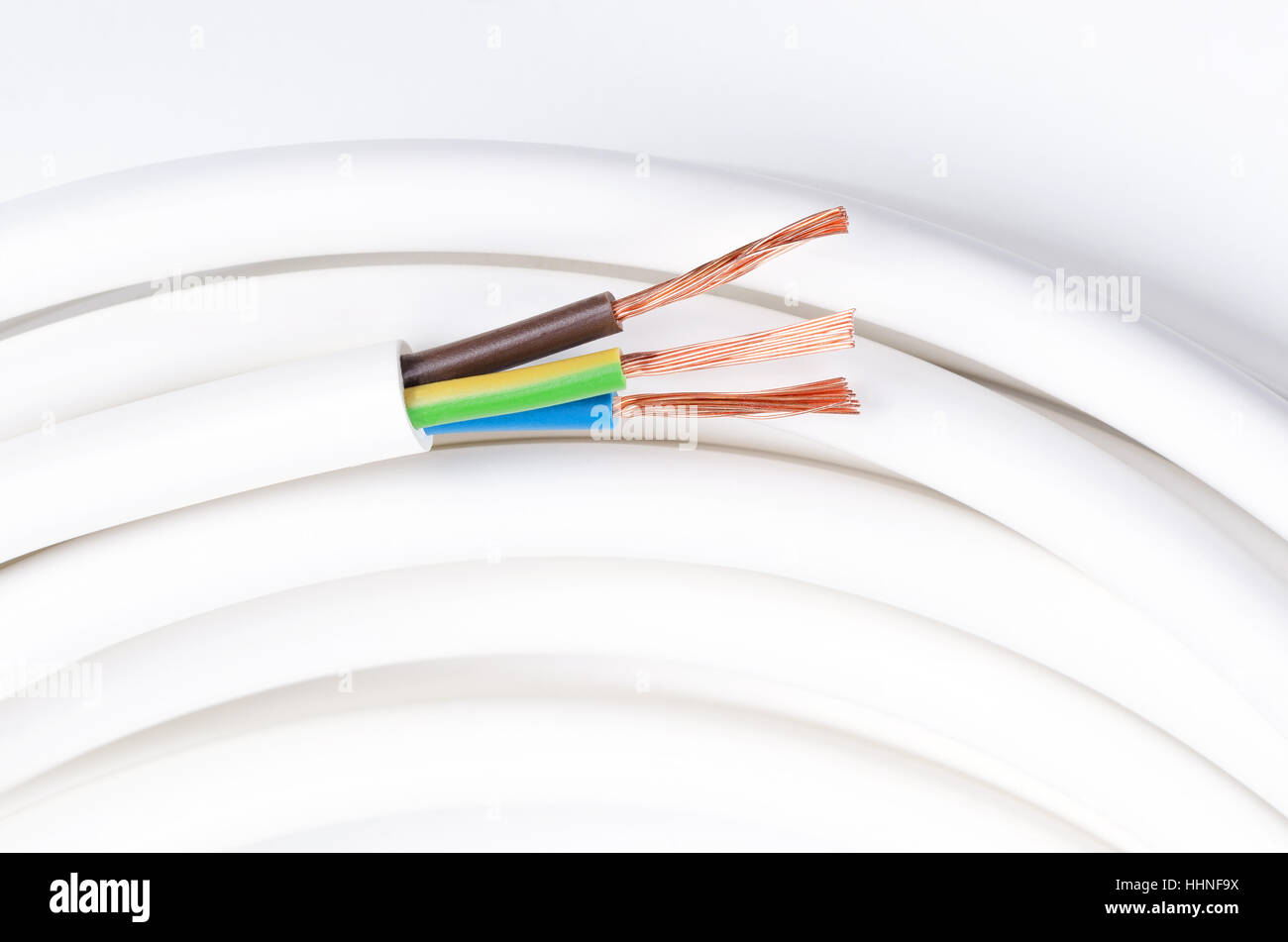 Electrical cable with three insulated conductors. Horizontal. Power cable cross-section. Cable jacket with wire insulation. Stock Photo