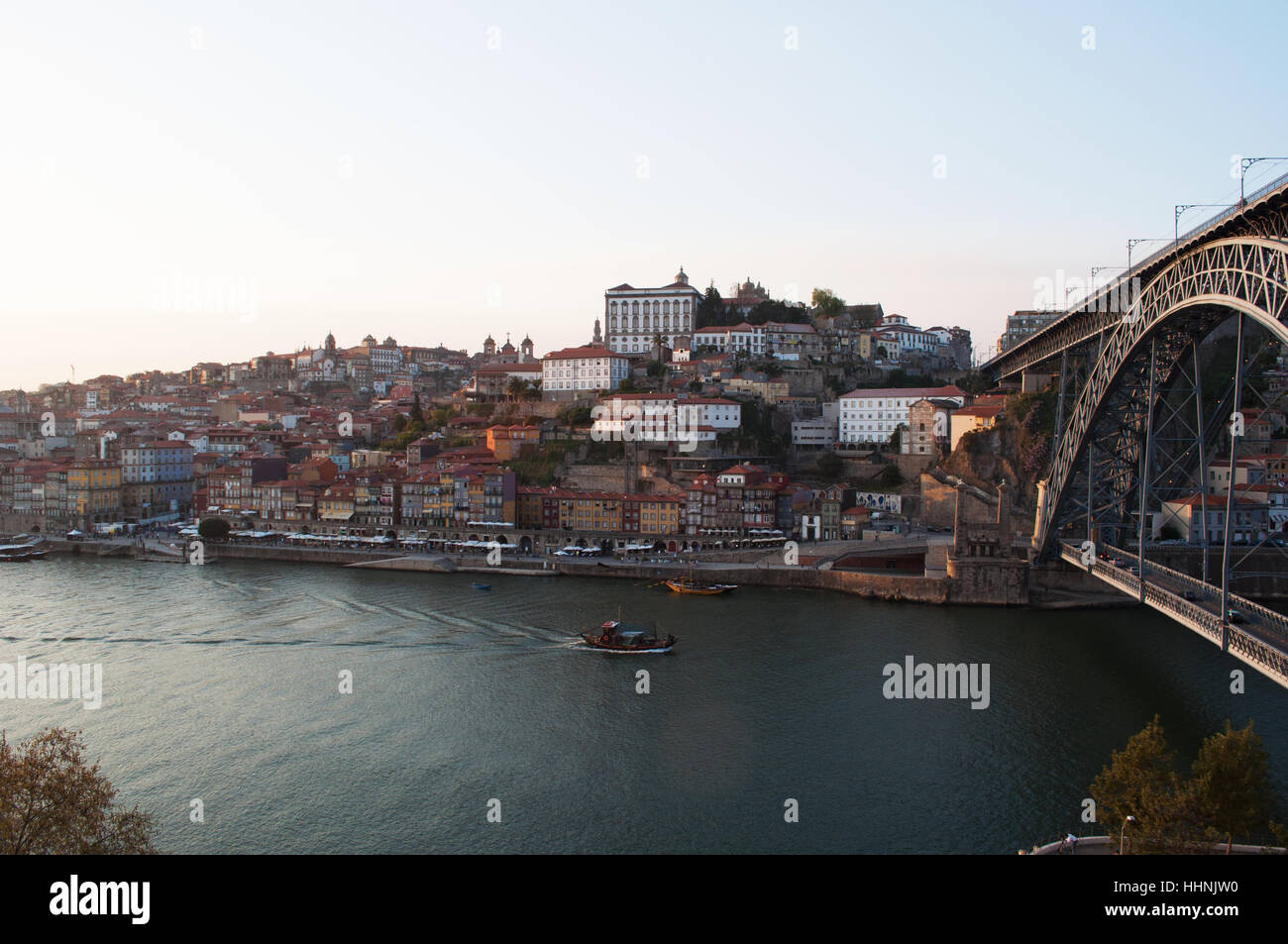 Portugal: boats at sunset and the skyline of Porto with view of the Luiz I, the double-decked metal arch bridge on Douro River Stock Photo