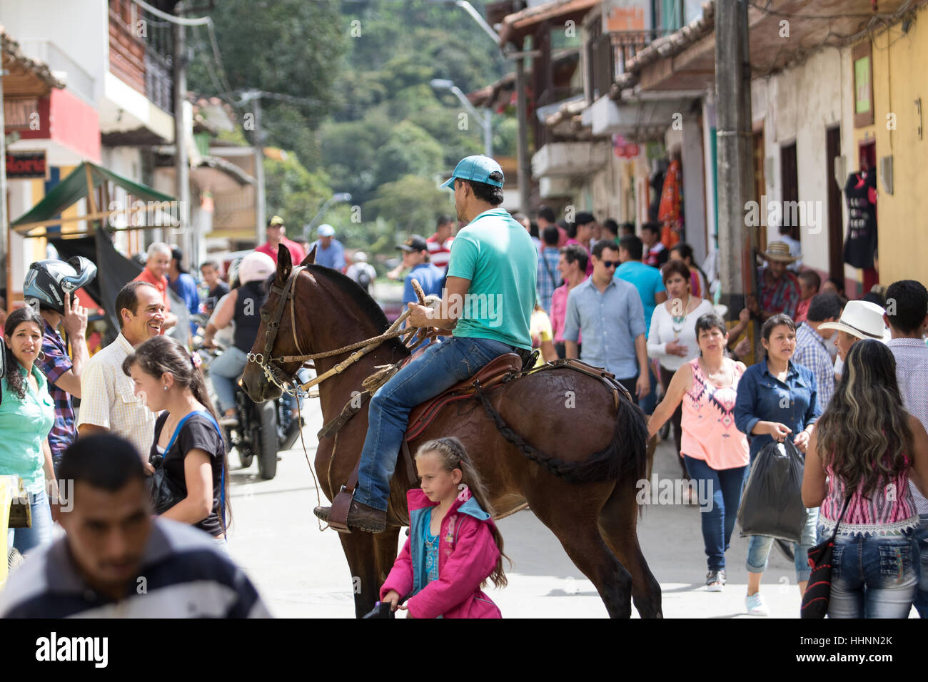 October 2, 2016, El Jardin, Colombia: a local man rides his horse through the crowded street of the coffee producing colonial town Stock Photo