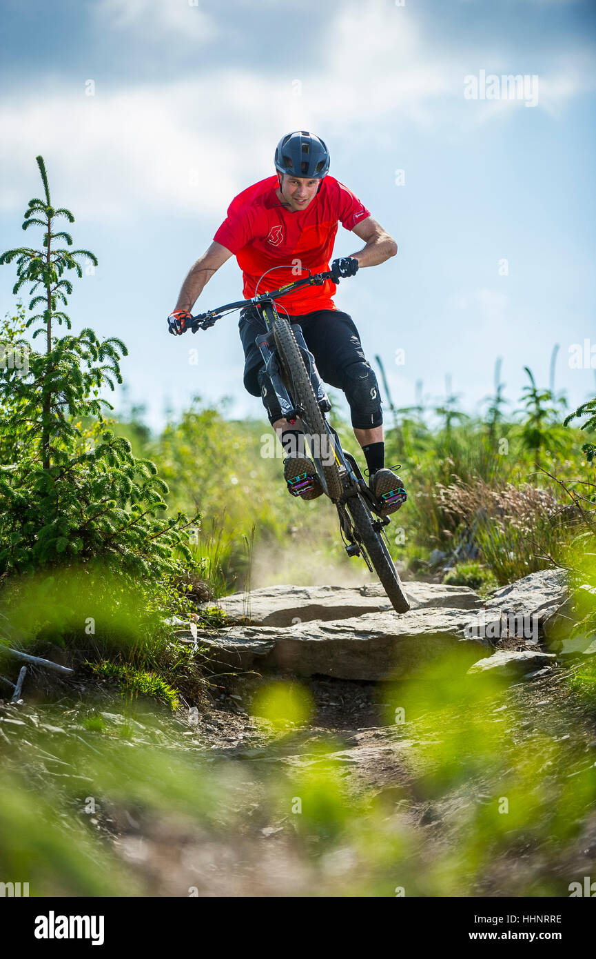 A mountain biker rides a rocky trail at Bikepark Wales near the town of Merthyr Tydfil in South Wales. Stock Photo