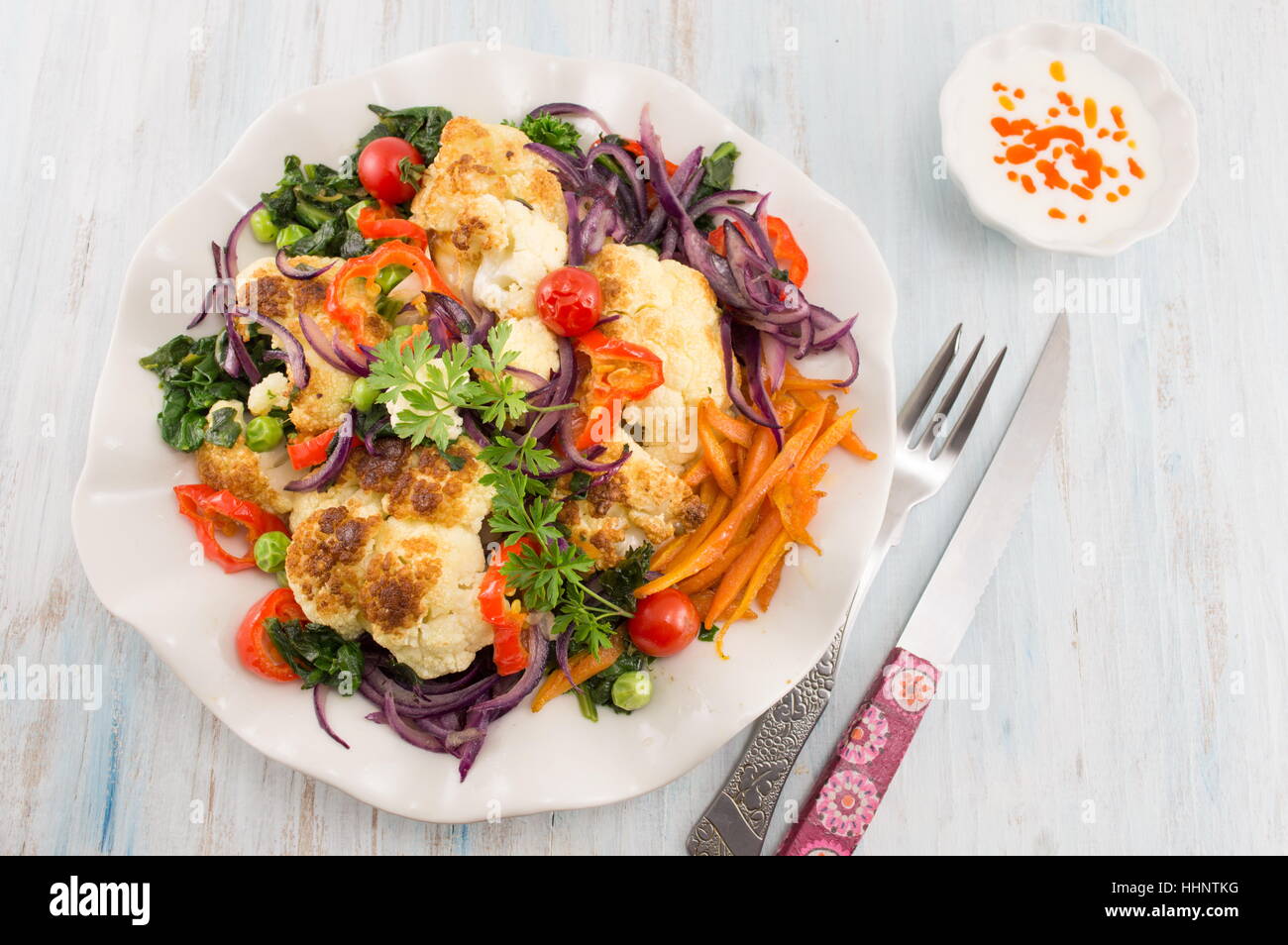 fried cauliflower and mixed vegetables with knife and fork Stock Photo