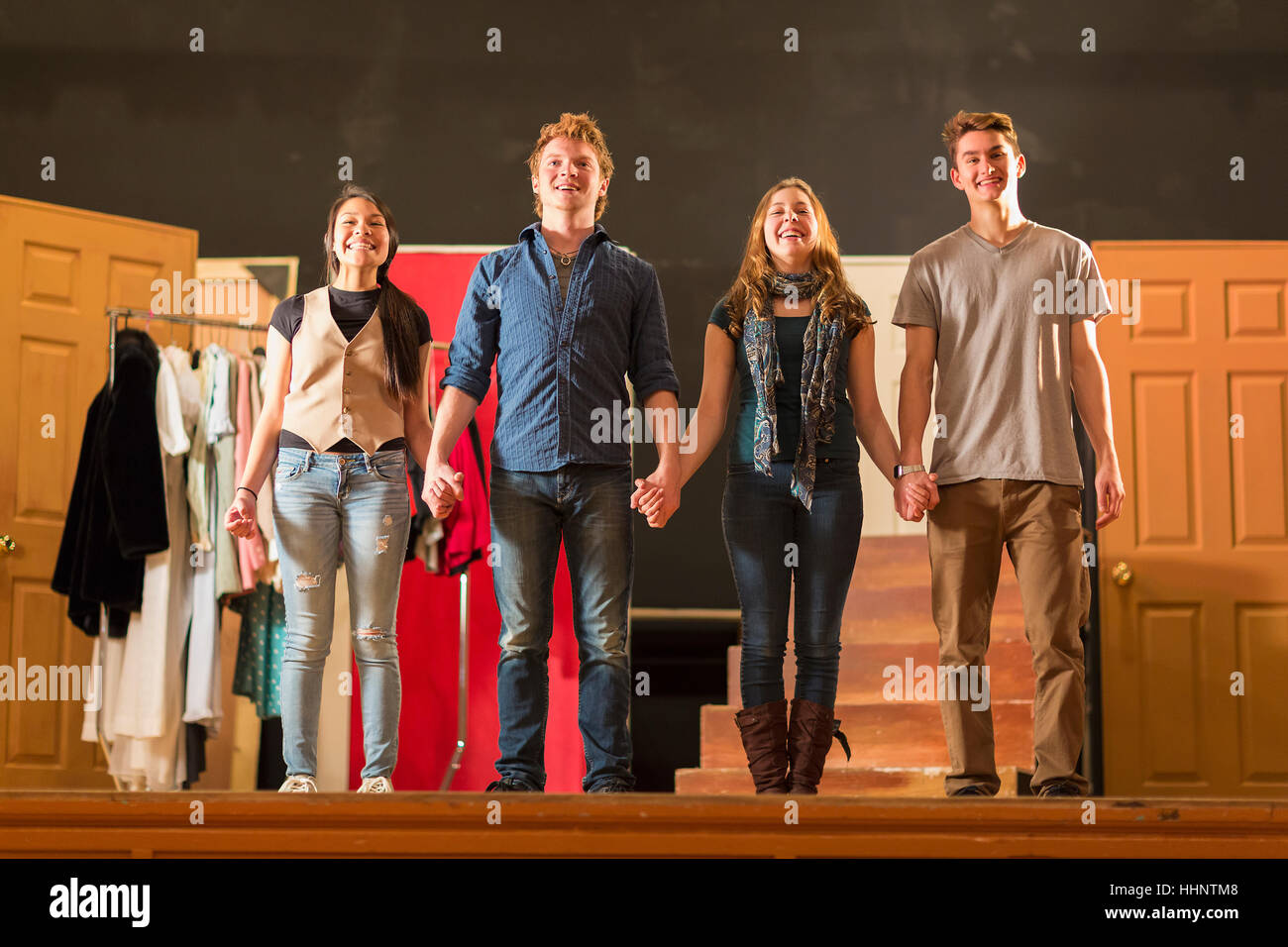 Students holding hands on stage Stock Photo