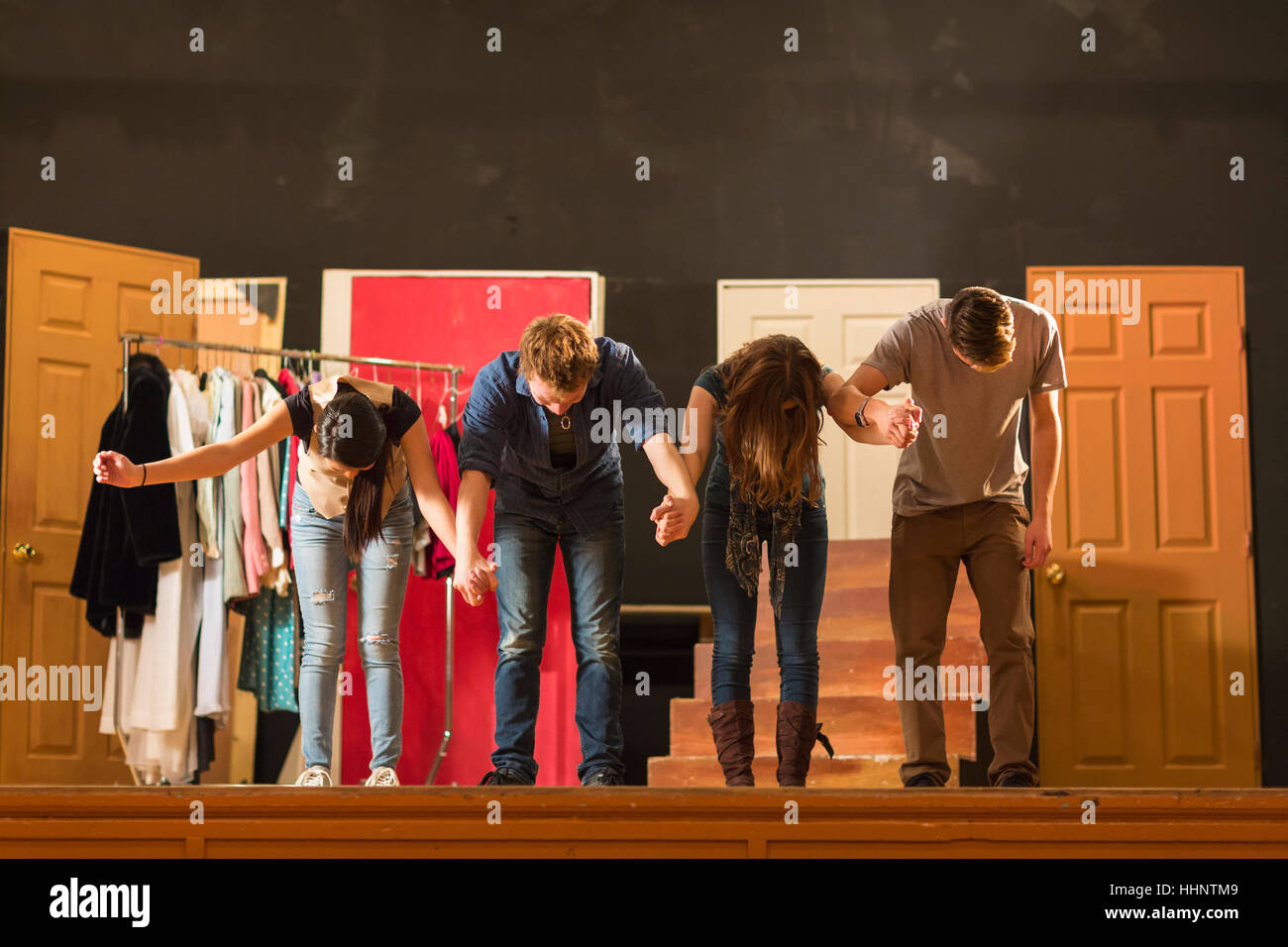 Students holding hands on stage and bowing Stock Photo