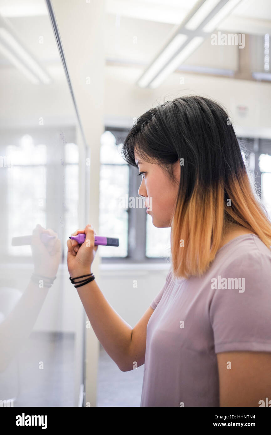 Chinese woman writing on whiteboard with marker Stock Photo Alamy