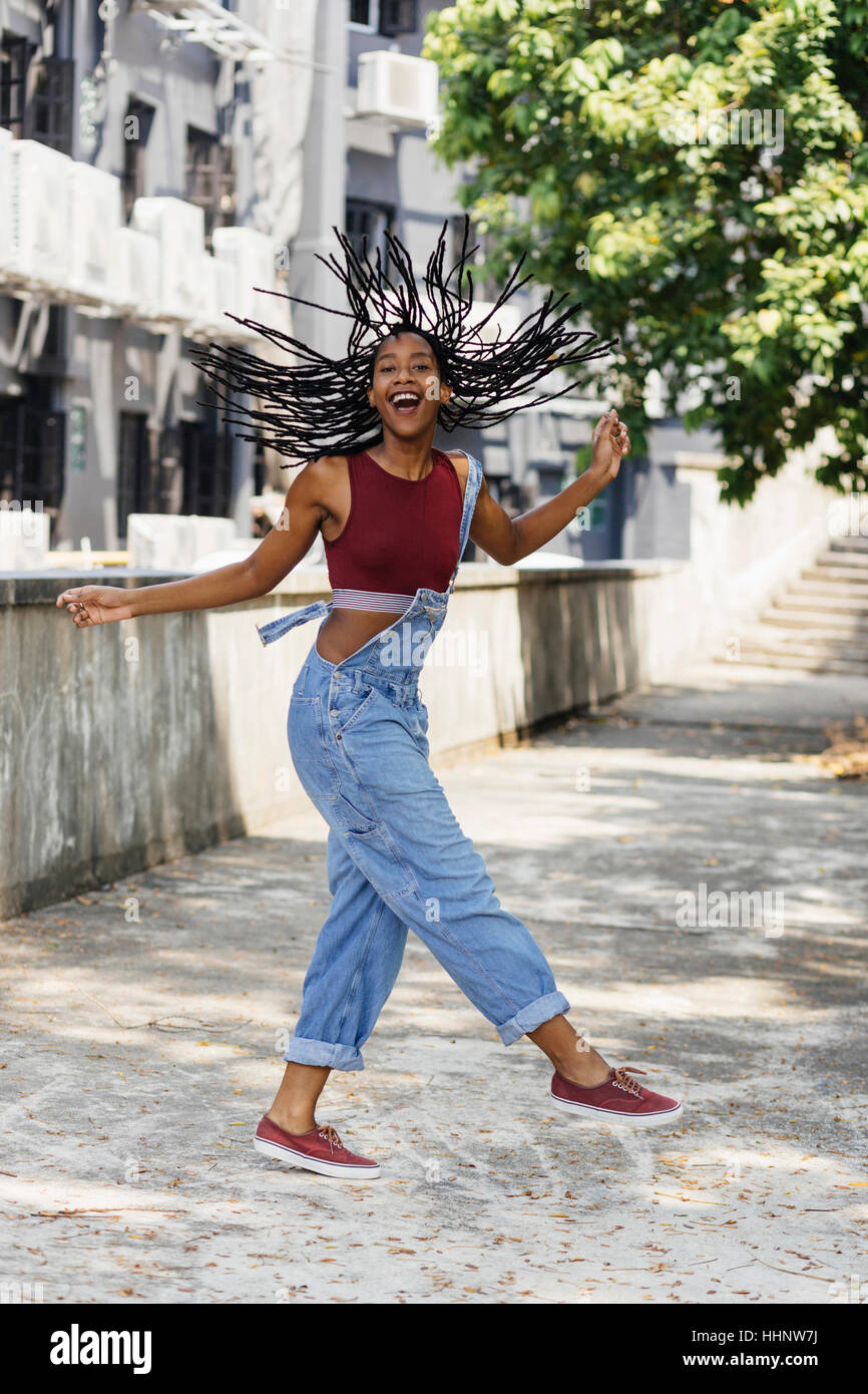 Carefree Mixed Race woman twirling hair outdoors Stock Photo