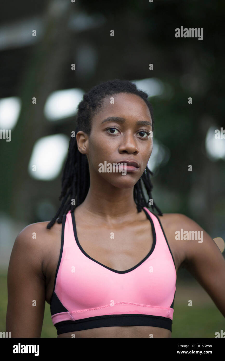 Serious Mixed Race woman wearing pink sports-bra Stock Photo