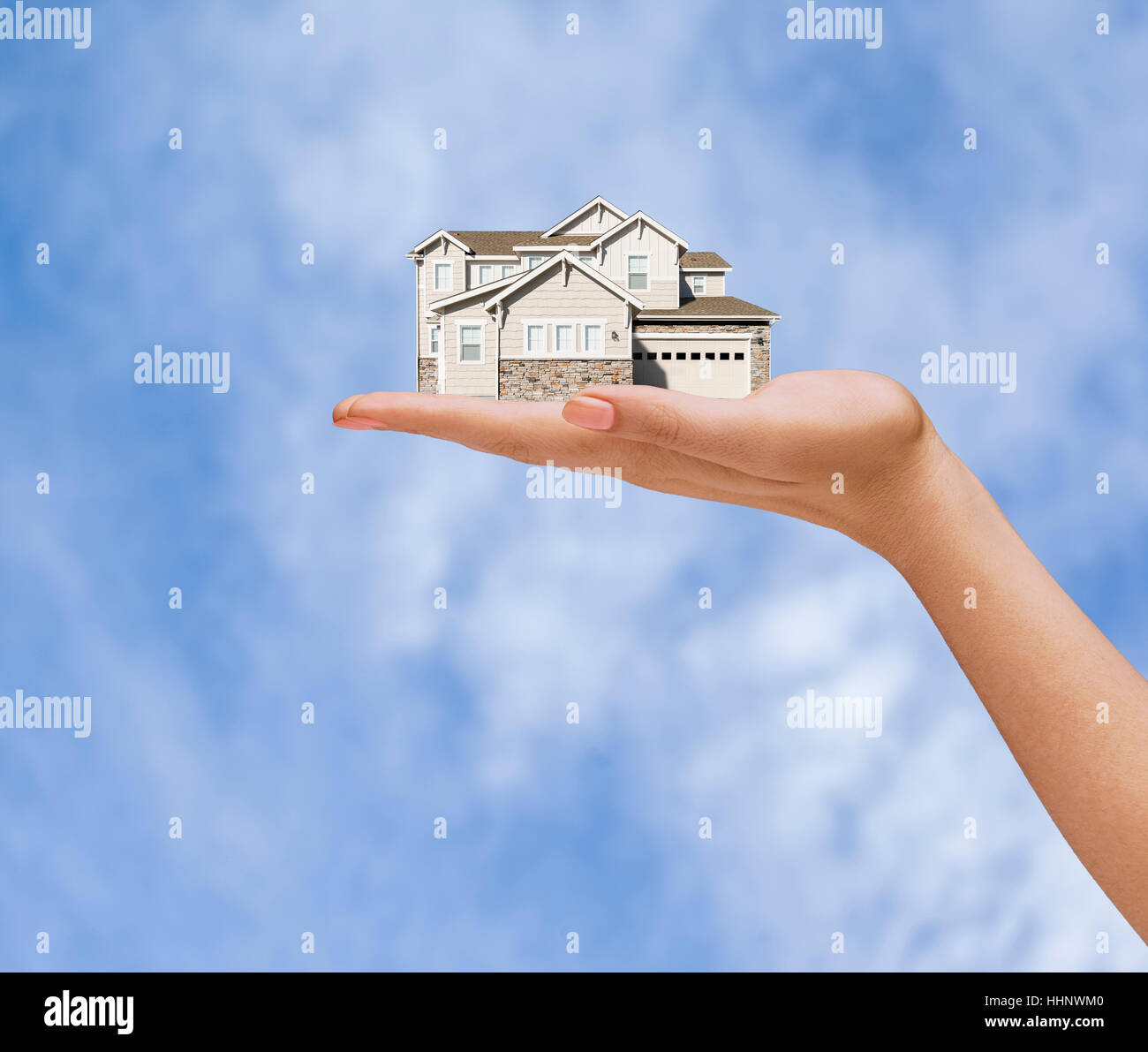 Hand of woman holding house in sky Stock Photo - Alamy