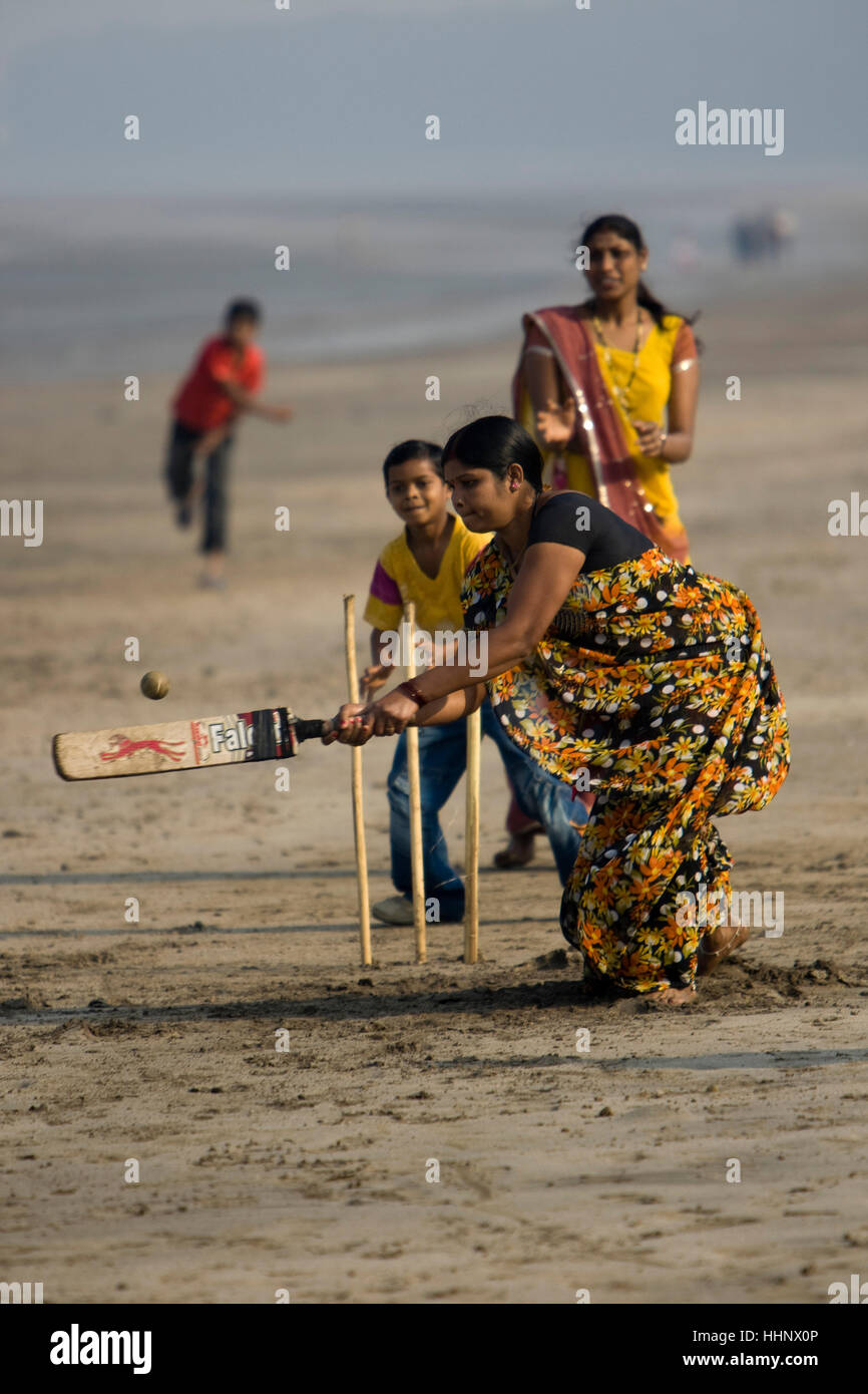 Indian women play cricket with children on school outing Jampore Beach Daman India Stock Photo
