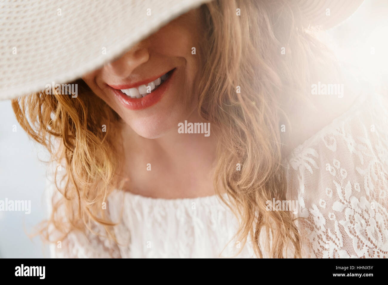 Sun hat covering face of Caucasian woman Stock Photo