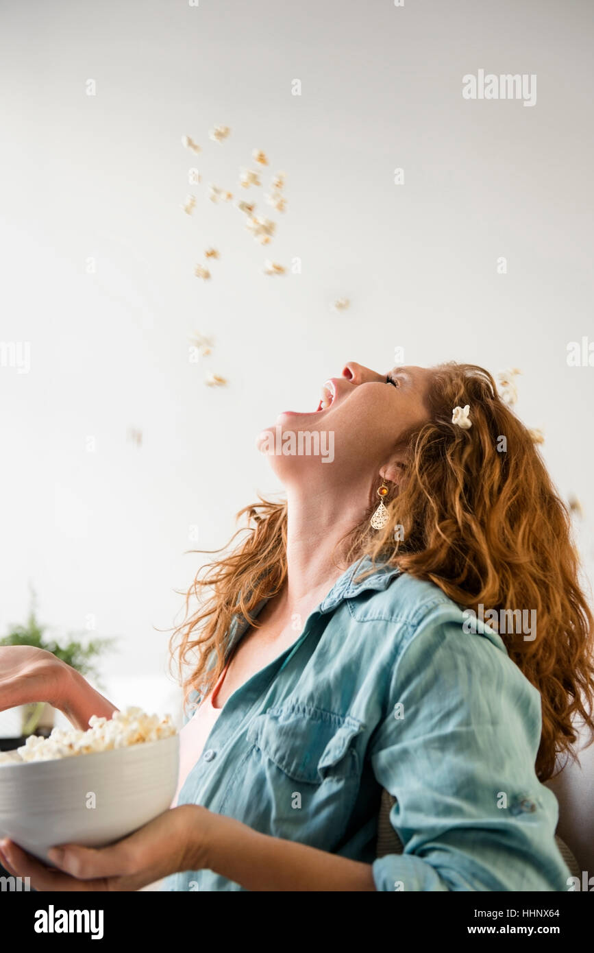 Caucasian woman throwing popcorn into mouth Stock Photo Alamy