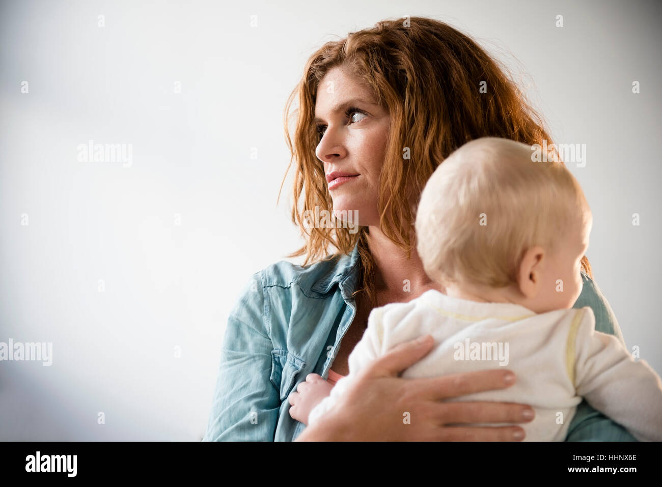 Frustrated Caucasian mother holding baby son Stock Photo