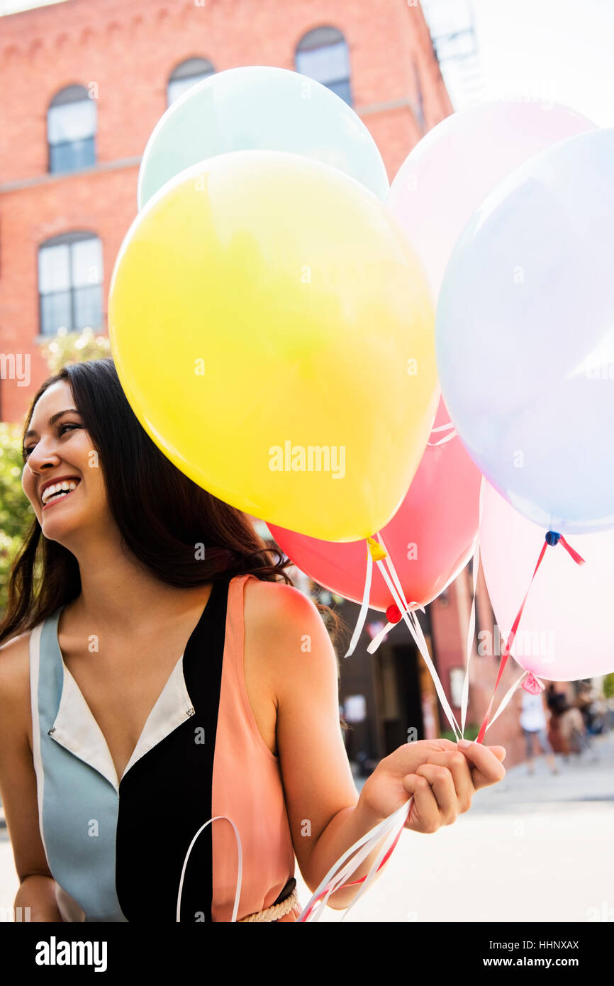 Thai woman holding balloons in city Stock Photo