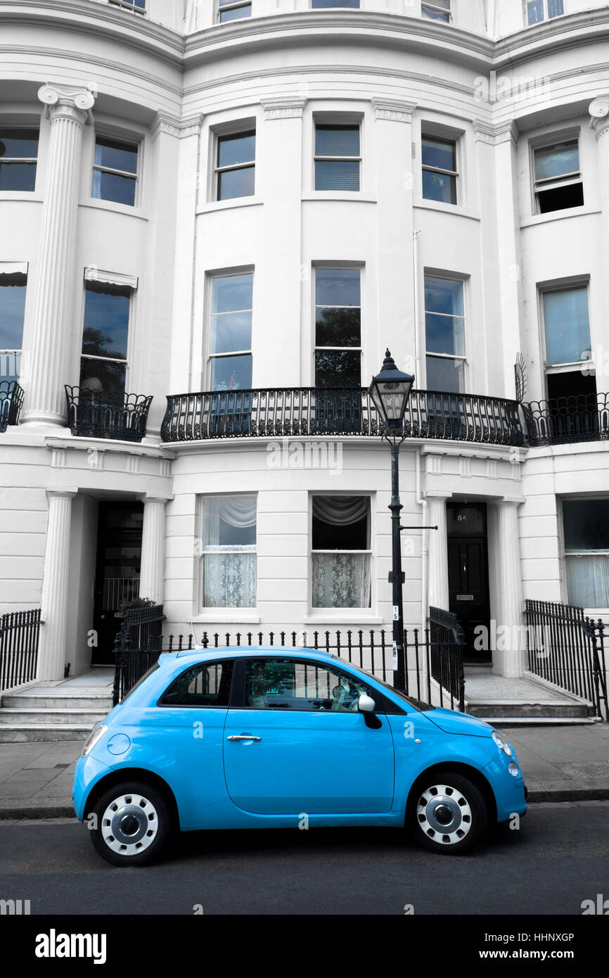 3 storey White Grand Regency British town house with light blue fiat car infront of the house, old lamp post metal railings Stock Photo