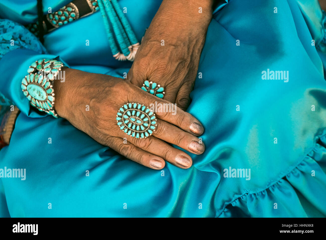 Lap of woman wearing traditional blue dress and rings Stock Photo