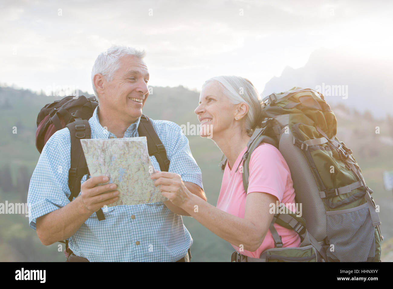 Caucasian couple hiking with map on mountain Stock Photo