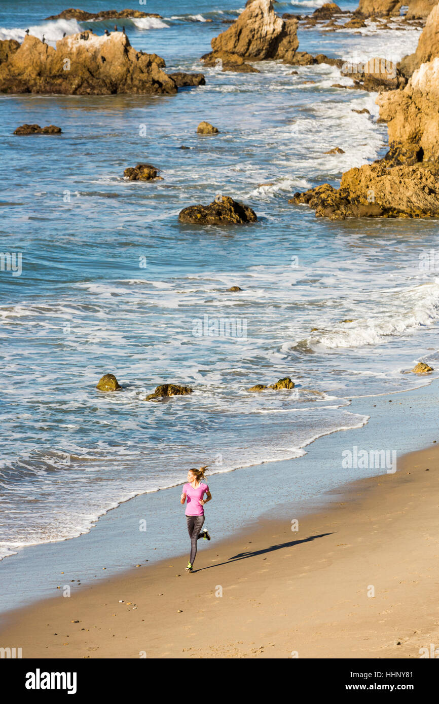 Caucasian woman running on beach Stock Photo