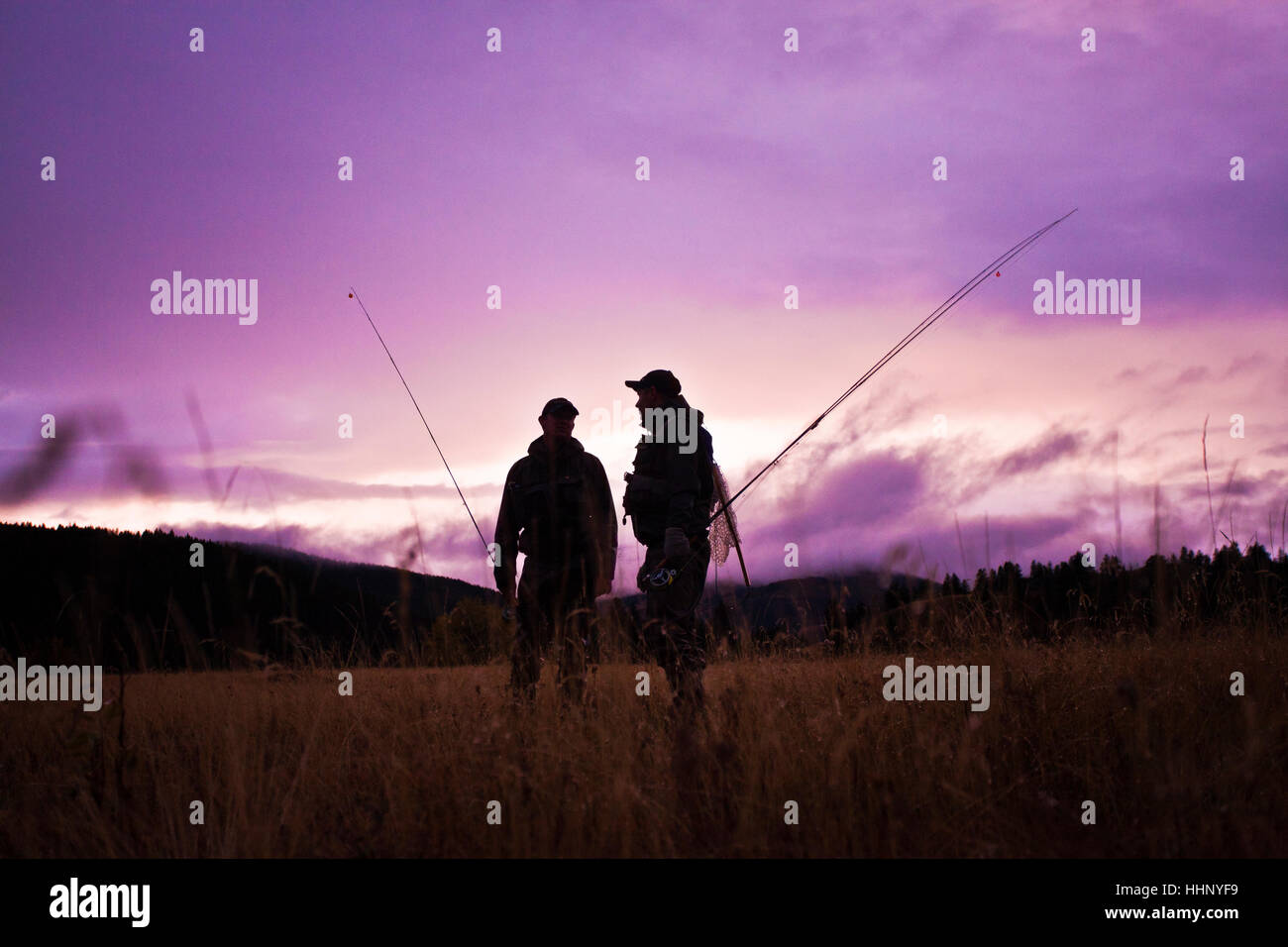 Caucasian men carrying fishing rods Stock Photo Alamy